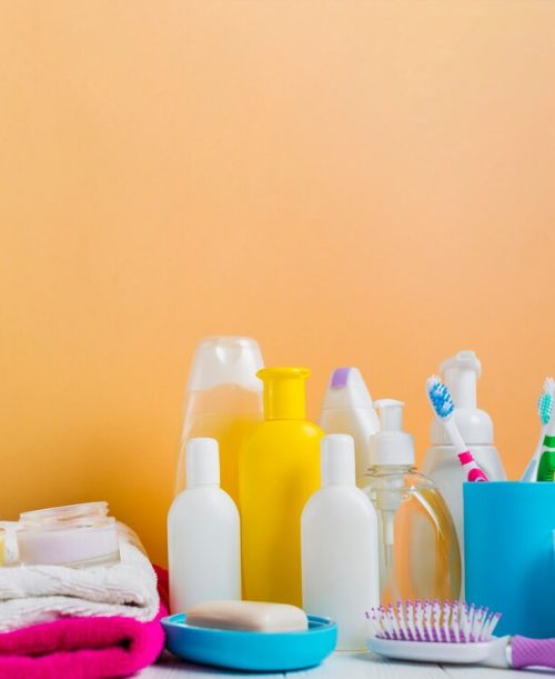 folded-towel-with-cosmetics-products-toothbrushes-against-orange-background_23-2147818038
